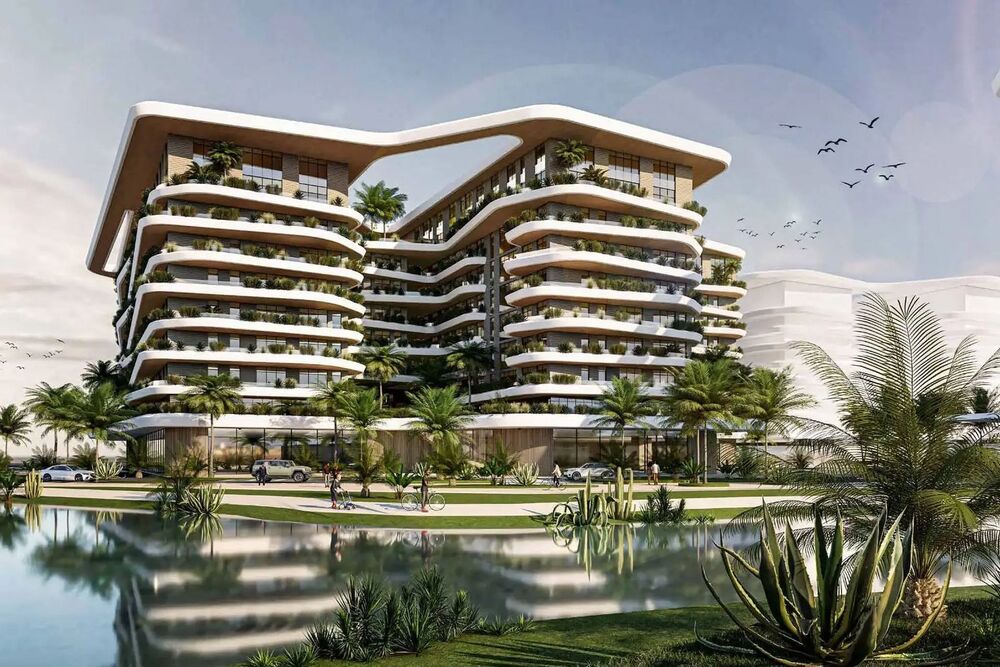 A render of the Wujha residential building at Knowledge Oasis Muscat, its terraces curving above a lagoon.